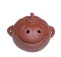 A small reddish-brown ceramic pumpkin-shaped vessel with a smiling face, photographed on a plain white background.