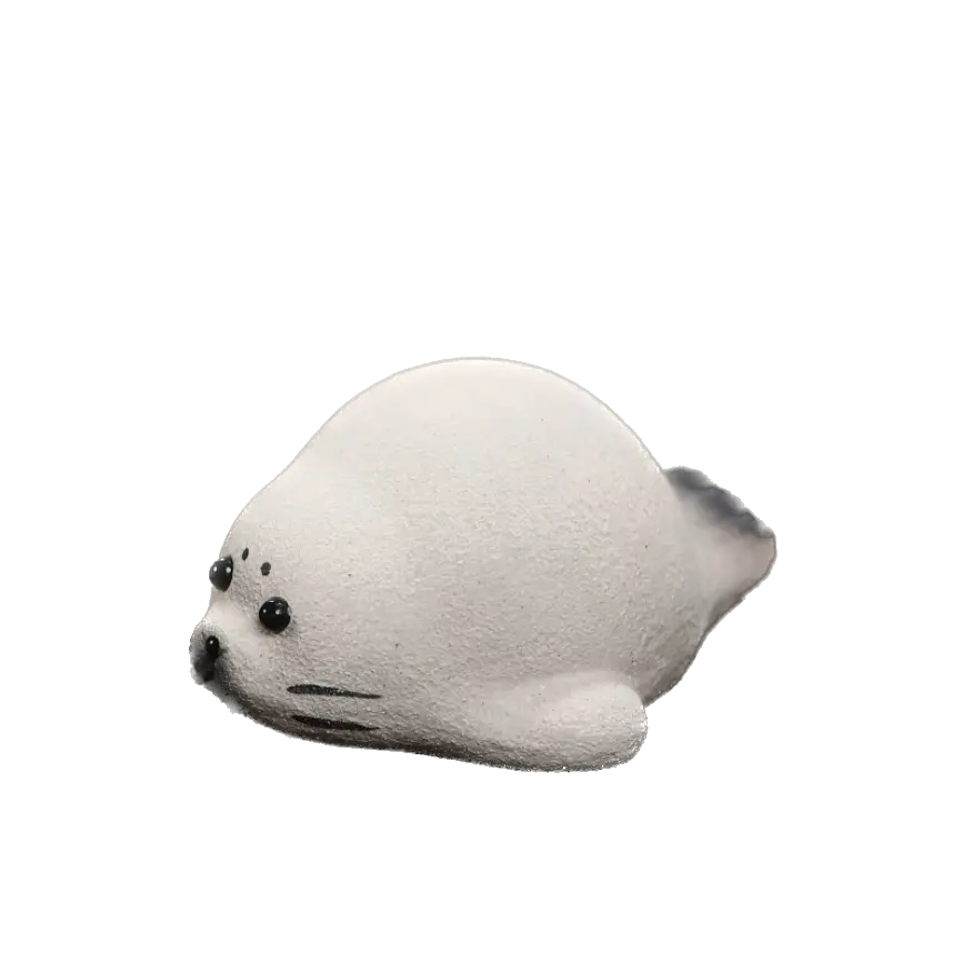 A small ceramic seal tea pet name Niko with a chubby white body, black eyes, and black whiskers, shown against a plain white background.
