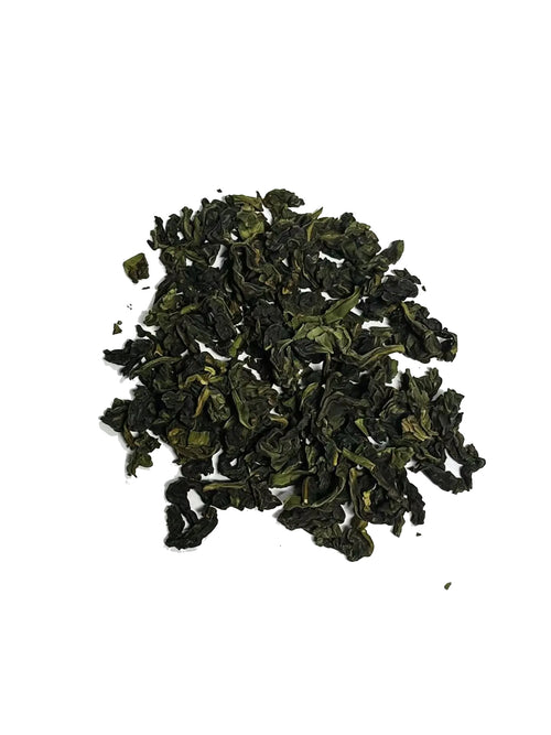 A small pile of dark green, tightly rolled loose-leaf Iron goddess tea on a plain white background.